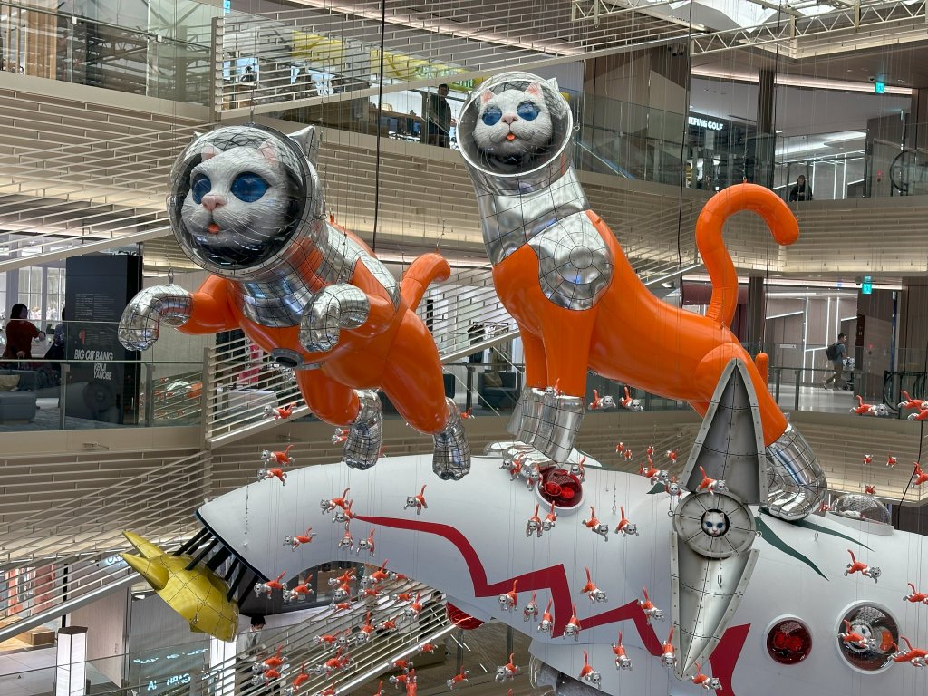 Photo of Big Cat Bang art installation at Ginza Six in Tokyo that shows cats in space suits flying out from their space ship